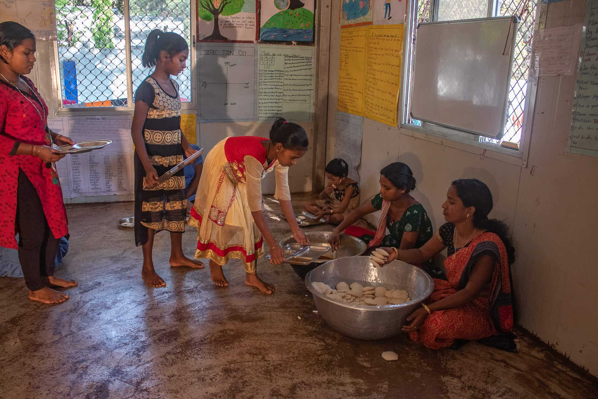 बच्चों को इडली बांटते हुए और बर्तन साफ़ करते हुए.